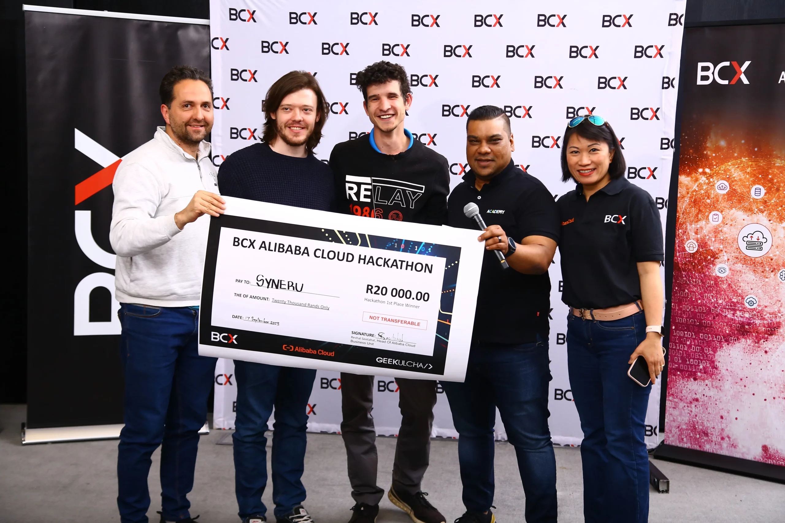 Syneru Holding the Check for winning the AI Hackathon